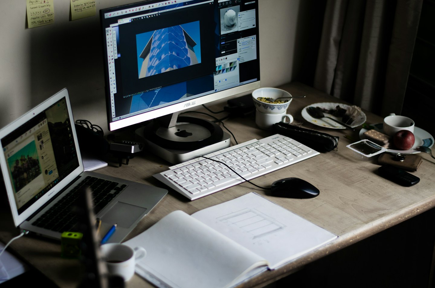 Cluttered desk with two computer screens and office supplies.